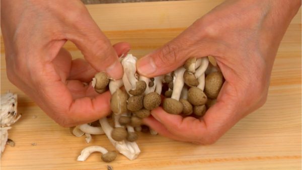 Remove the stem ends from the shimeji mushrooms. Separate the mushrooms into bite-size pieces with your hands.
