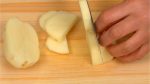 Coupez la pomme de terre épluchée en deux dans la longueur. Coupez-la en tranches demi-lunes d'1 cm (0.4 inch). 