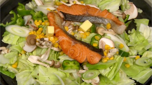 Place the salmon fillets and butter on top of the vegetables.