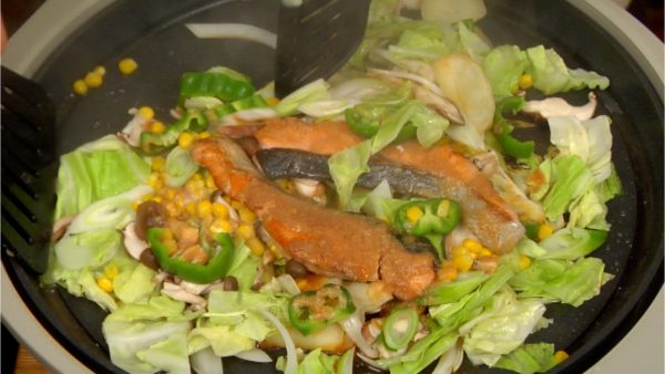 Remove the lid. Flip the vegetables over with the turner, distributing the sauce evenly.