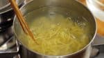 鍋にたっぷりの湯を沸かし、麺をほぐして熱湯に入れます。菜箸で軽くかきませて麺がくっつかないようにします。