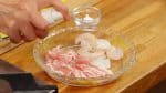 将海鲜和五花肉片一起放在盘子里，五花肉片应切成5厘米的大小。撒上少许的盐，或者你也可以不撒盐来减少的总量。加入胡椒粉，喷一些在清酒上。
