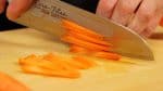 Coupez la carotte en tranches de 2 mm (0.1 inch). Empilez les tranches et coupez-les en lamelles très fines. 
