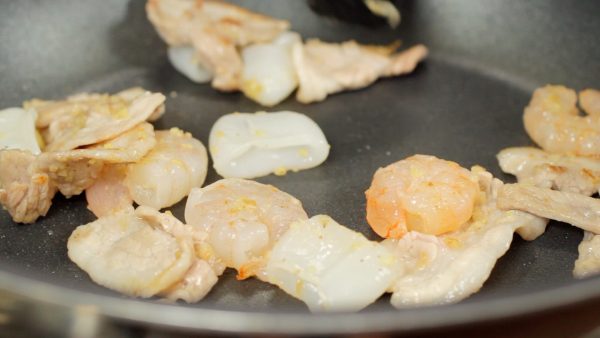 When the pork is almost cooked, add the shrimp and squid and stir-fry.