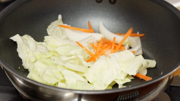 And now, add slightly less than 1 teaspoonful of vegetable oil. Add the cabbage leaves, carrot and onion.