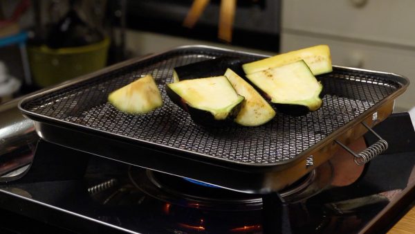 And now, let’s grill the vegetables. First, place the eggplant on the grill with the skin side facing down.