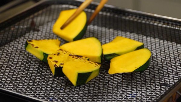 Next, arrange the kabocha slices on the grill. Kabocha take a long time to cook so grill them on low heat.