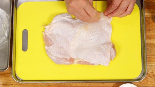 把有雞肉皮的面朝上放至。用ㄧ根竹籤在皮上戳一些小洞足以讓等ㄧ下倒上的醃醬能夠讓雞肉充分的吸收味道且可以防止雞肉放進烤箱時破裂。