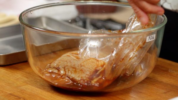 Now, cut the bottom of the bag with kitchen shears and place the chicken into a heat-resistant container with the skin side facing up. You may want to rinse your hands after touching the raw meat.