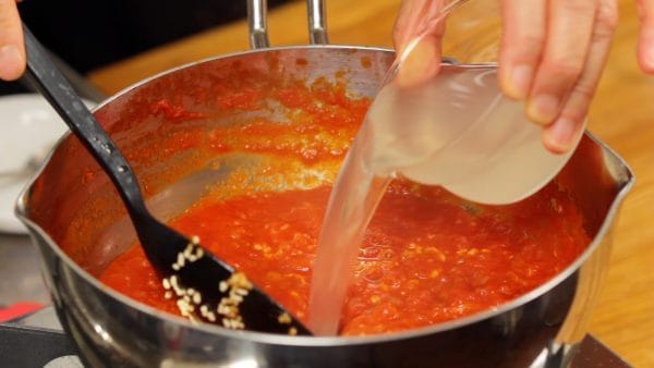 Add some water to adjust the consistency so that the noodles can hold more sauce. We are adding chicken stock instead of water in the video, but if the sauce is relatively thin, you can skip this diluting process.