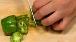 Corte los pimientos verdes en círculos. Evite usar la parte que contiene semillas para hacer que el plato sea más presentable.