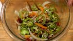 Ajoutez les poivrons et plongez les légumes dans la sauce au vinaigre avec une paire de baguettes de cuisine. 