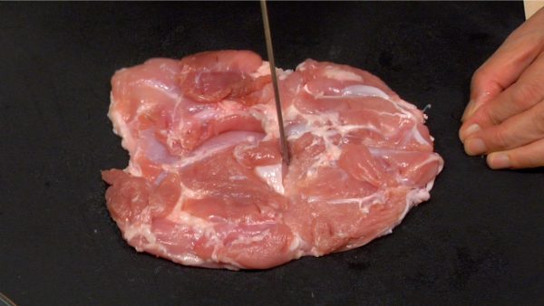 Let's prepare the chicken thigh. Make cuts in tough stringy parts with the tip of a knife.