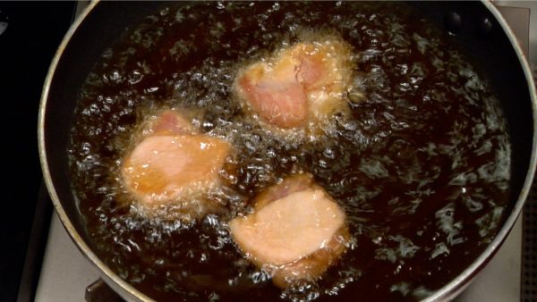 Heat the oil to 170 °C (340 °F) and place the chicken into the oil from large pieces. Check the small bubbles and the sizzling sound to get the right oil temperature.