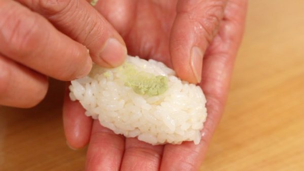 Spread the wasabi on top and place the rice onto the board.