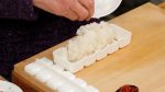 握り寿司用の押し型の使い方をお見せします。軽く手酢で濡らし100gの寿司飯をとります。