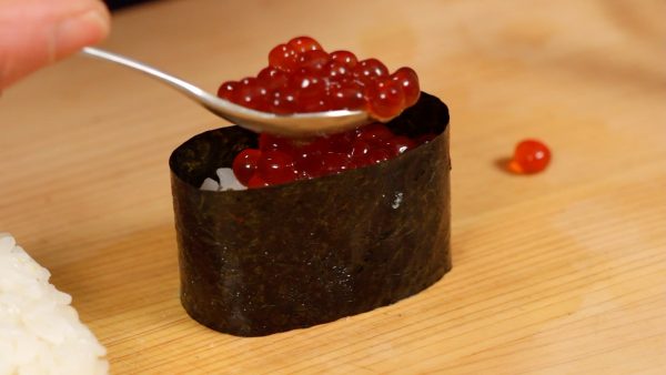 Make the base of the gunkanmaki and top with the ikura shoyuzuke, marinated salmon roe.