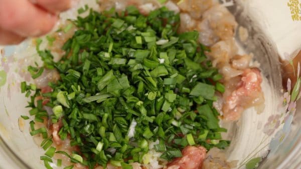 Then, add the chopped long green onion and the garlic chives. Combine all the ingredients.