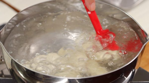 And now, let’s make the Sui-Gyoza. Place the gyoza into a large pot of boiling water. Gently move the gyoza in the water immediately after adding them. This will prevent the wrappers from sticking to the bottom.