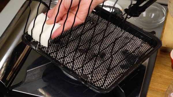 Now, coat the grilling basket with vinegar. This will help to prevent the fillet from sticking. Turn on the burner.