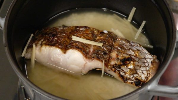 Then, place the grilled tai into the pot and add the shredded ginger root.