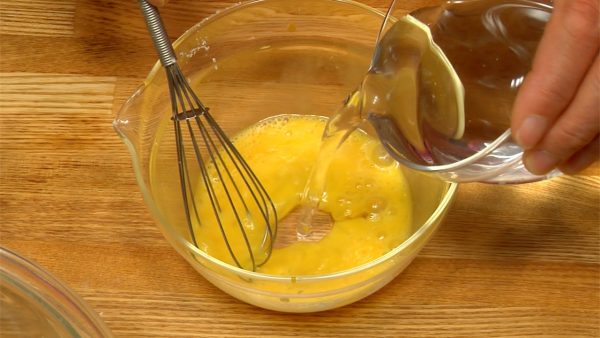 Ensuite, préparez la pâte à taiyaki. Battez l’œuf dans un bol. Ajoutez l'eau à l’œuf et mélangez. 