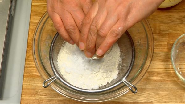 Sàng bột bánh bông lam, muối nở và đường vào một cái bát khác.