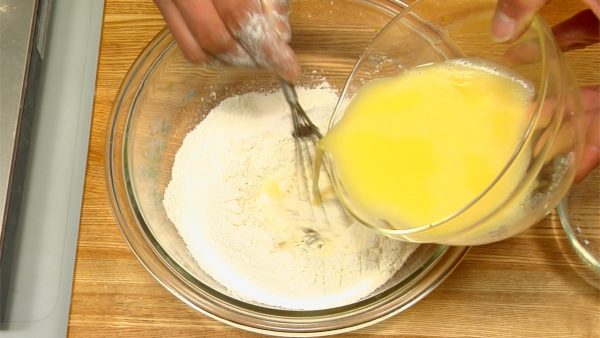 粉の中央に卵液を少しずつ流し込みながら、泡だて器で混ぜます。