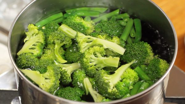 The broccoli is cut into bite-size pieces, and the bean pods are cut into 3 cm (1.2") pieces.
