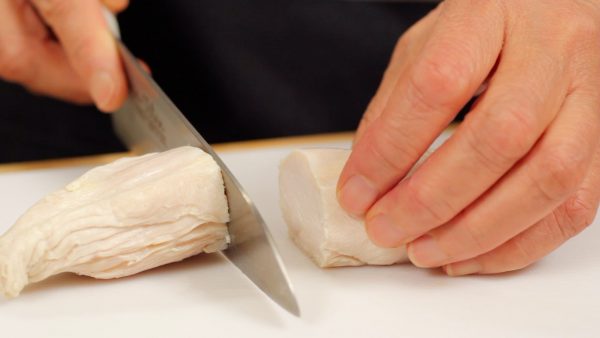 把煮熟的雞胸肉切成兩半。