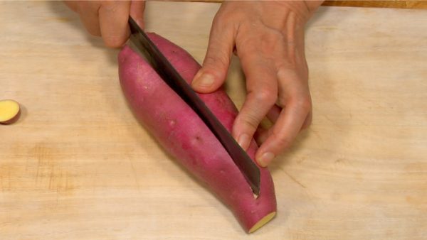 Let's cut the sweet potato. Wash the potato beforehand and trim off both ends. If it is thick, cut vertically in half.