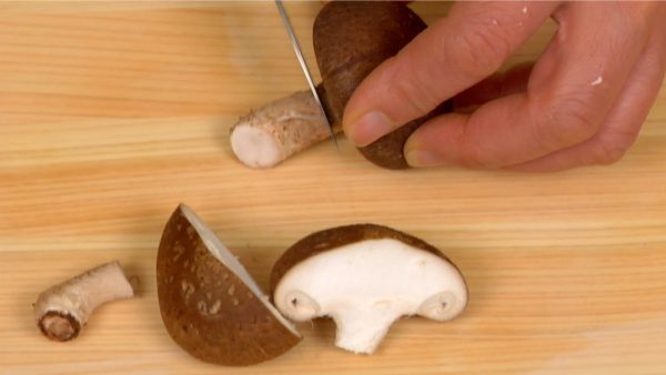 Remove the stems of the shiitake mushrooms. Cut the mushrooms in half.