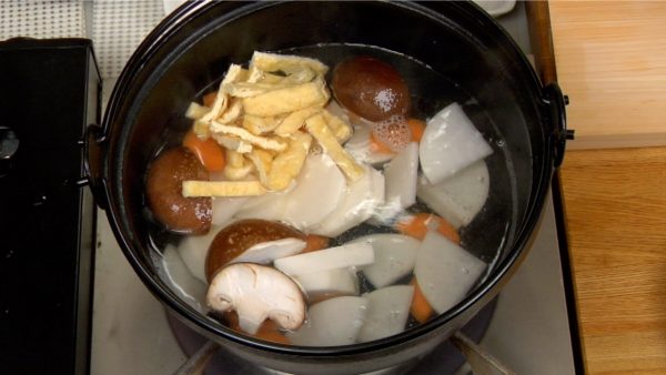 Cho củ cải daikon, cà rốt, khoai sọ, nấm hương và aburaage (đậu phụ mỏng chiên) vào. Làm nóng nồi ở lửa lớn.