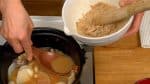 Una volta reso uniforme, scodellare della zuppa di miso dalla pentola e aggiungerla alla pasta di natto.