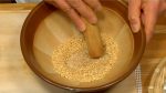 Cho hạt mè (vứng) rang vào cối suribachi. Nghiền hạt mè (vừng) bằng chày surikogi.