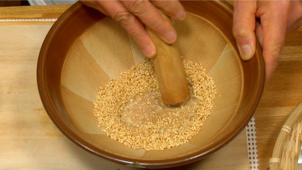 Put the toasted sesame seeds in a suribachi bowl. Grind the sesame seeds with a surikogi pestle.