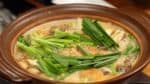 肉煮熟，蔬菜软化后，加入切成4厘米长的韭菜，浸在汤中。