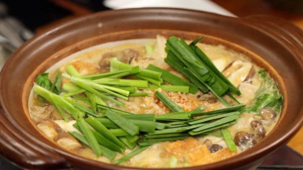 When the meat is cooked and the vegetables are softened, add the garlic chives cut into 4 cm pieces and submerge them in the broth.