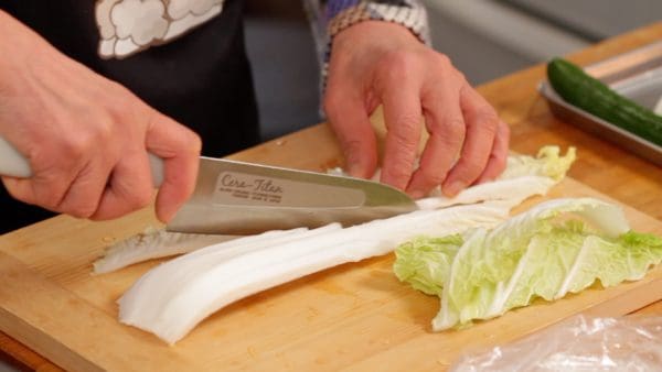 Let's prepare the vegetables. Separate the napa cabbage leaves into the thick white part and leafy part.