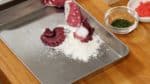 With kitchen paper, remove the excess water from each piece and place it onto a tray covered with all purpose flour.