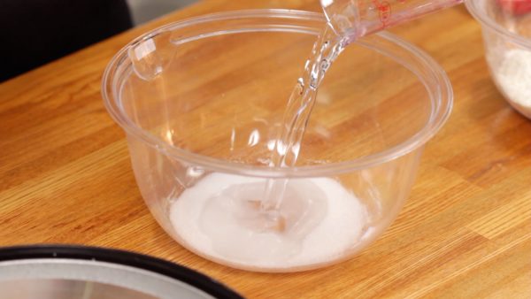 First, let's make the dough. Add the water to the sugar in a bowl and dissolve it well.