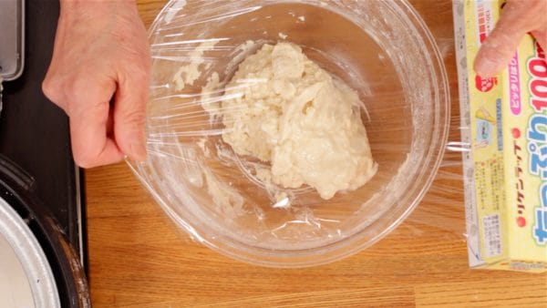 Cover the bowl with plastic wrap and let it rest in the refrigerator for 20 to 30 minutes. This process will help to distribute the water throughout the flour evenly.
