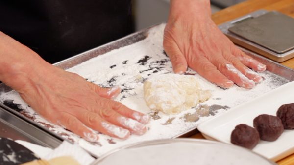 Put a generous amount of flour on your hands to prevent the dough from sticking. Then, turn the dough over.