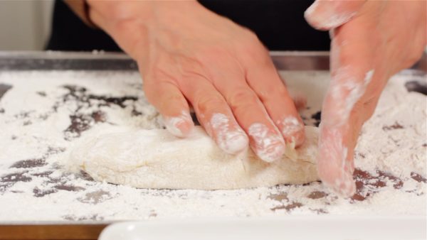 Dust with flour and stretch the dough into a long oval.