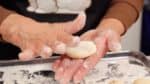 Pressez légèrement sur la pâte avec vos paumes. La pâte est très collante, continuez donc à couvrir vos mains de farine.