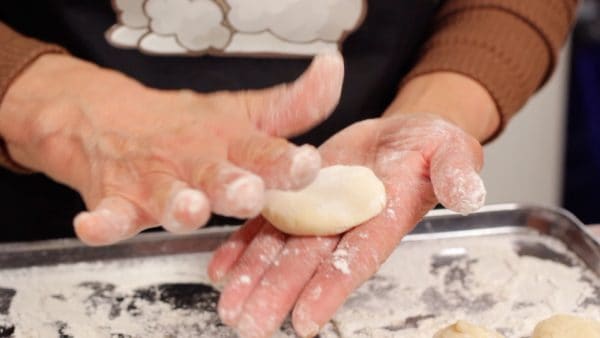 Lightly press the dough with your palms. The dough is very sticky so keep dusting your hands with flour.