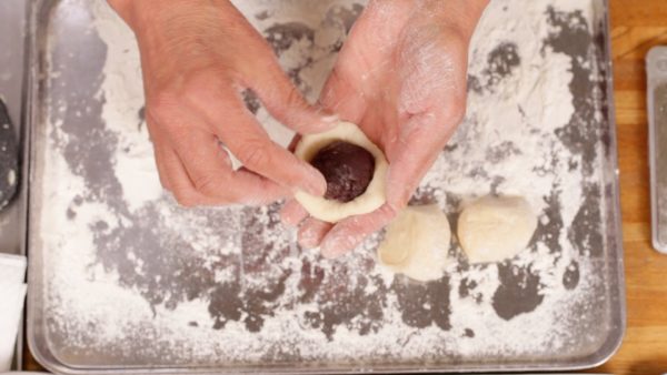 Place the dough with the clean side facing down, and put the anko, red bean paste in the center. Each anko ball weighs 25 g.