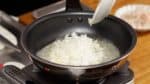 Sobald die Butter geschmolzen ist, füge die gehackte Zwiebel hinzu und schwitze sie unter Rühren an.