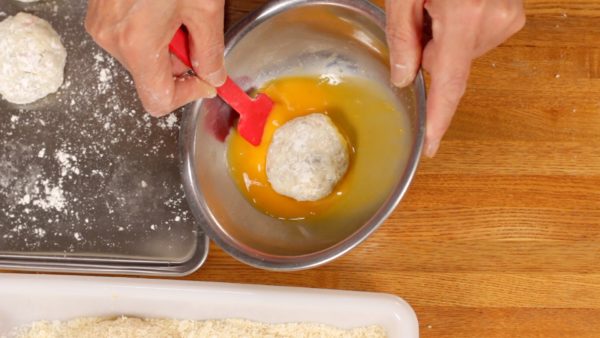 Next, lightly dust off the excess flour and dip the filling in the beaten egg.