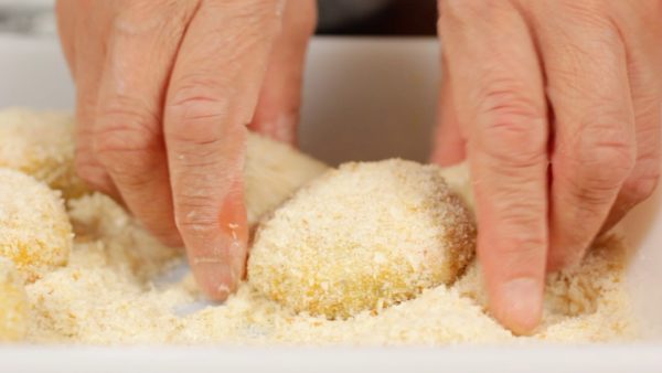Then, cover the fillings with a generous amount of panko, Japanese breadcrumbs and arrange them on a tray.